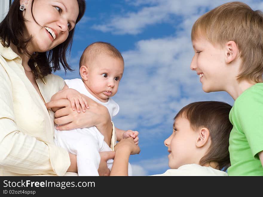 Mother with three children at the background of the sky