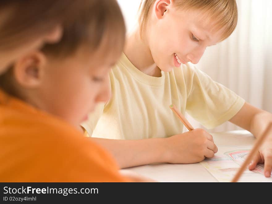 Mother sitting at the table and draws with his sons. Mother sitting at the table and draws with his sons