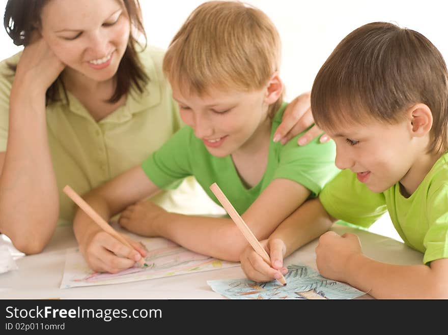 Mother at the table and draws with his sons. Mother at the table and draws with his sons