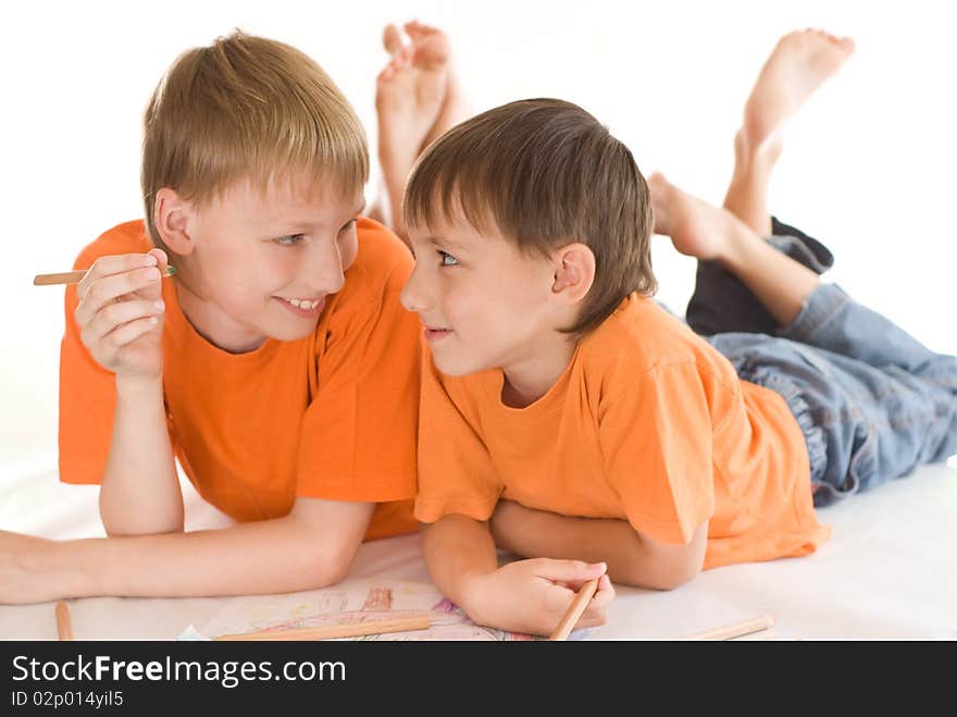 Happy brothers lying on the floor and draw. Happy brothers lying on the floor and draw