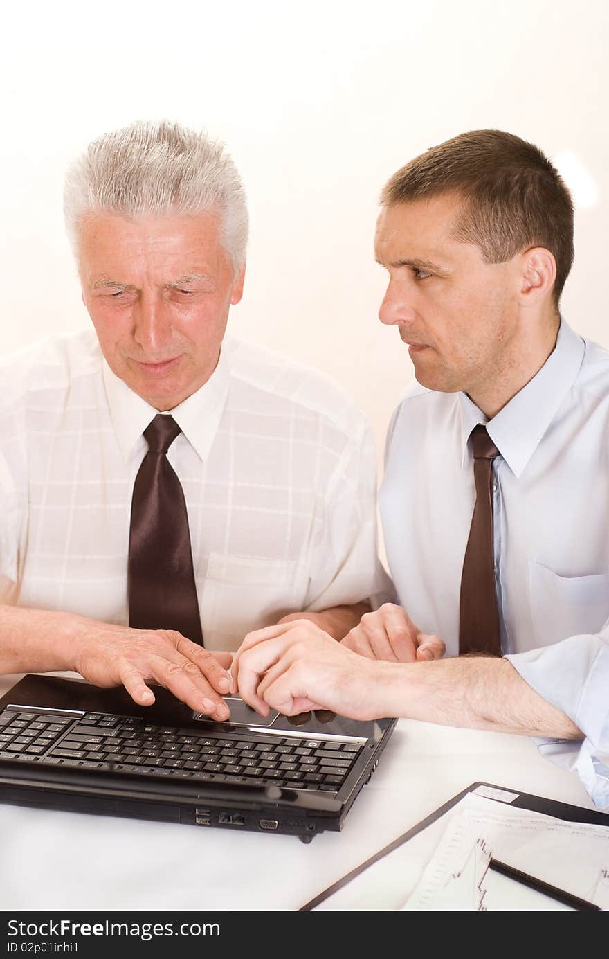 Two businessmen working together on a white