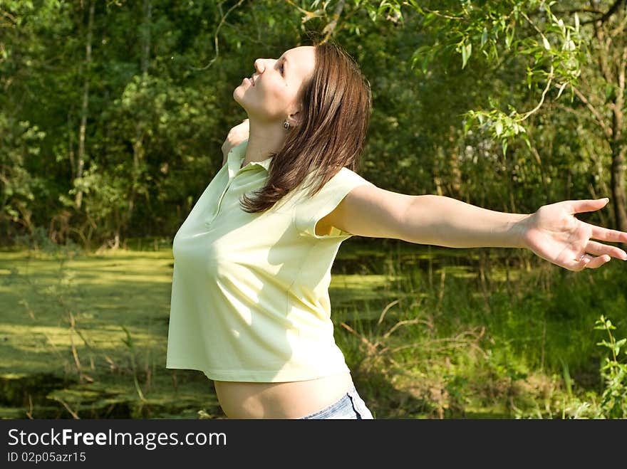 Happy beautiful girl standing in summer park