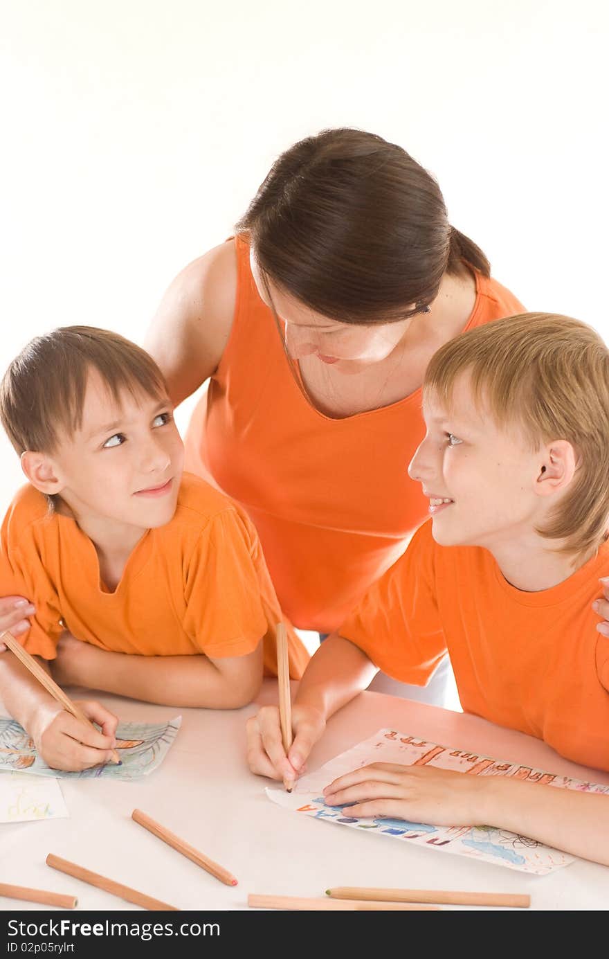 Mother at the table and draws with his sons. Mother at the table and draws with his sons