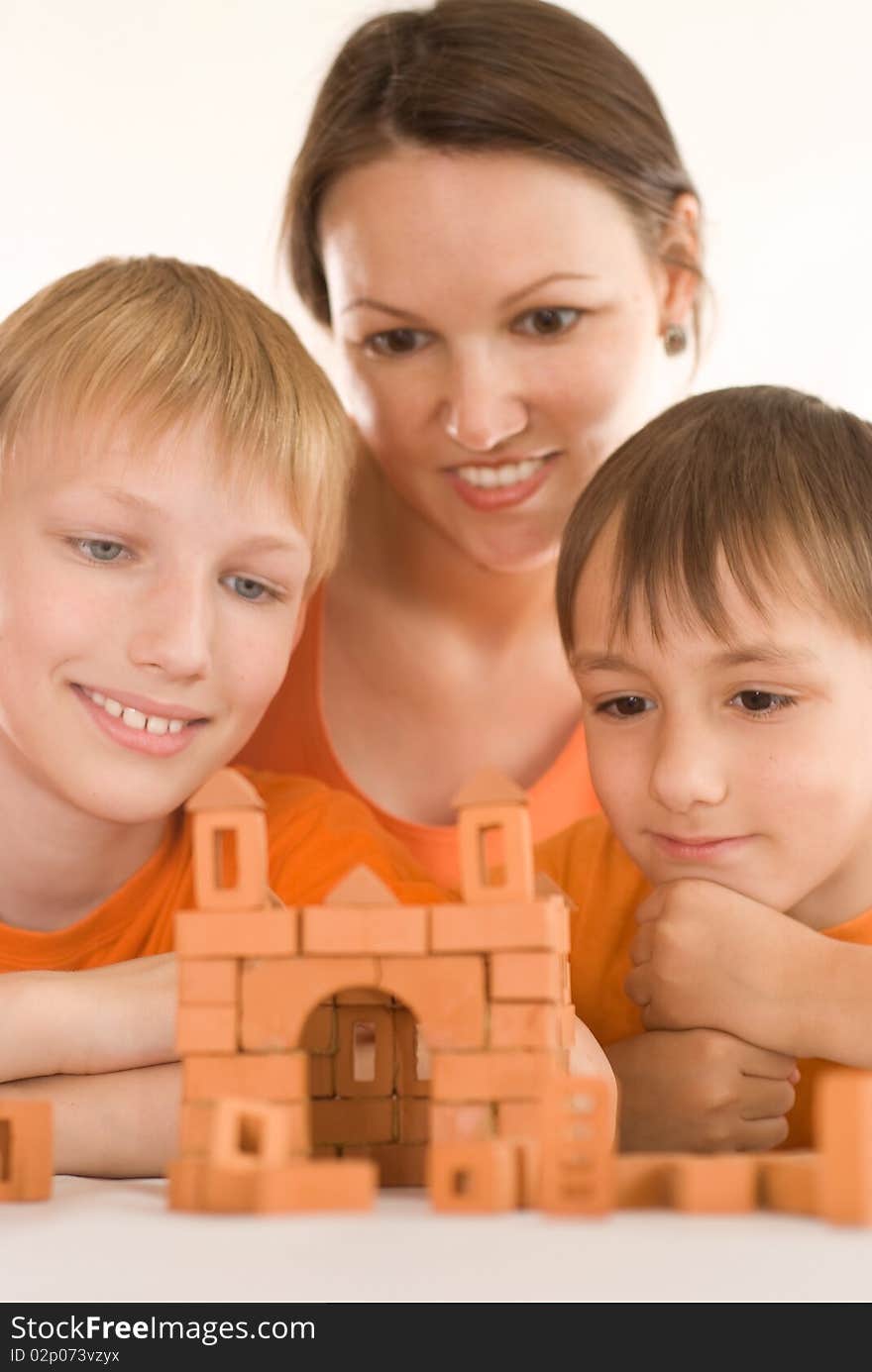 Young mother sitting at the table with two sons. Young mother sitting at the table with two sons