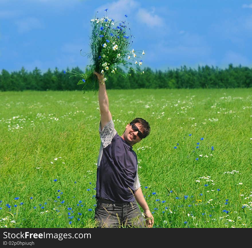 Young adult man with bouquet of wildflowers