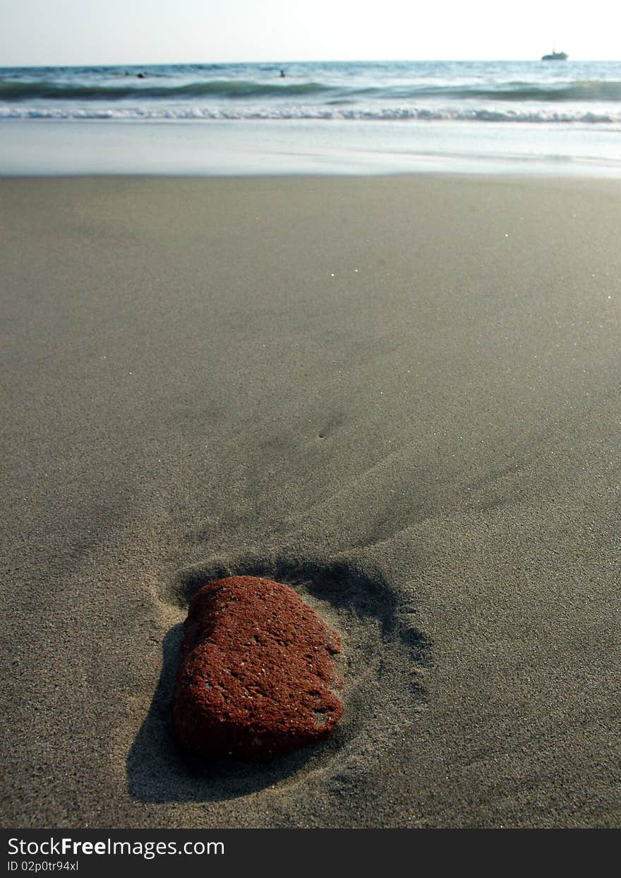 Red stone in the sand after ebb in Puerto Escondido, Mexico