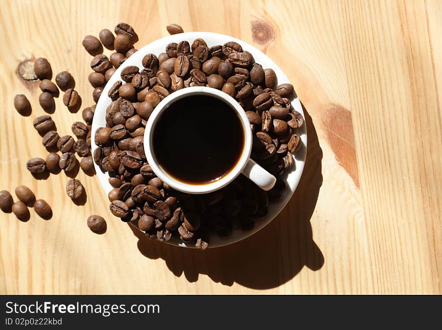 Coffee cup and coffee beans on wooden background