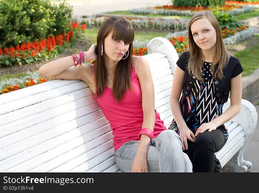 Two female friends sitting on bench