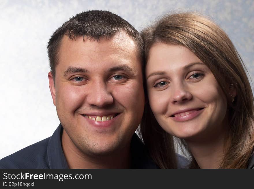 Young smiling couple over light defocused background. Young smiling couple over light defocused background