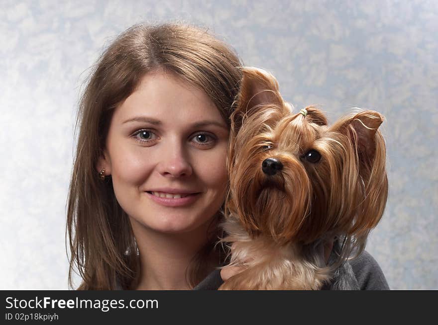 Young woman with her Yorkshire terrier portrait over light defocused background. Young woman with her Yorkshire terrier portrait over light defocused background