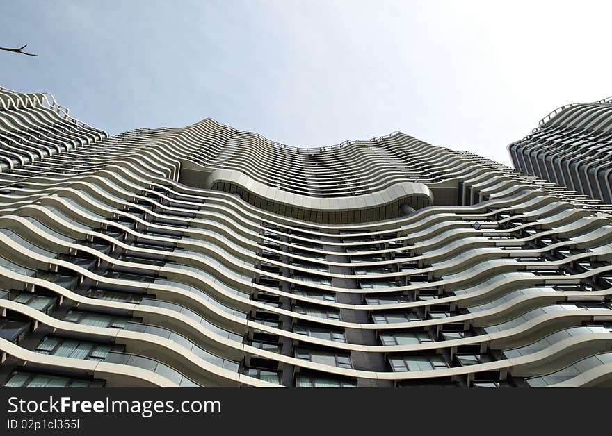 Cityscape of Urban building with windows in wave pattern under blue sky