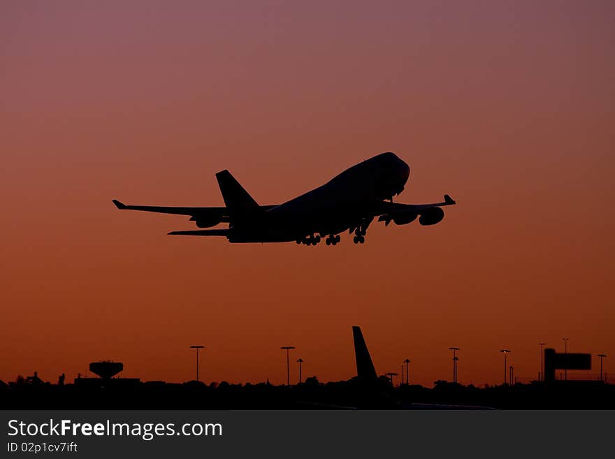 Boeing 747 jumbo jet taking off at dusk.