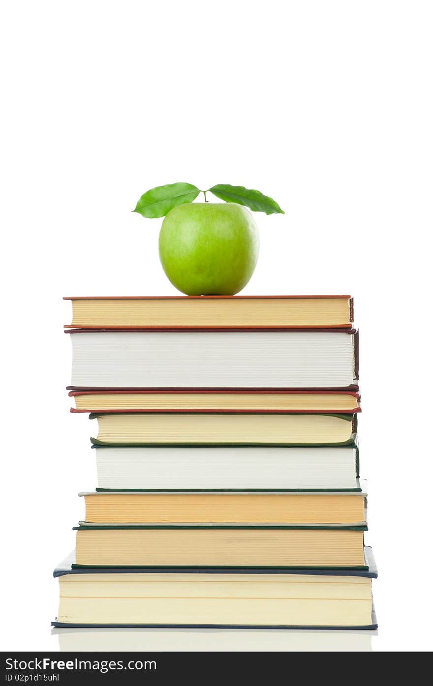 Stack of books and green apple isolated on white background