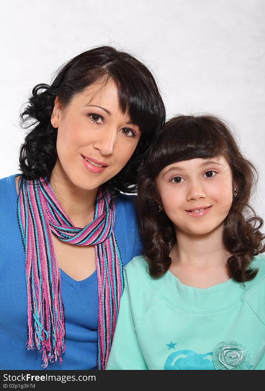 Portrait of mum and the daughter on a light background. Portrait of mum and the daughter on a light background