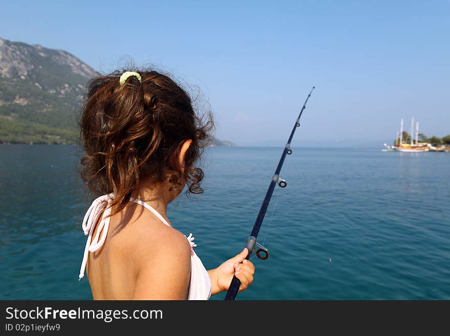 Young fisher girl at the sea