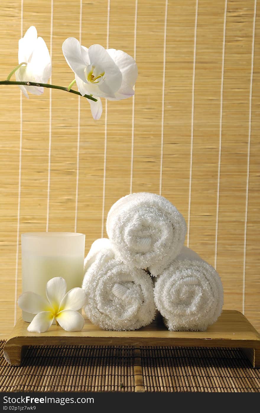 Spa still life with roll towel, candle , frangipani