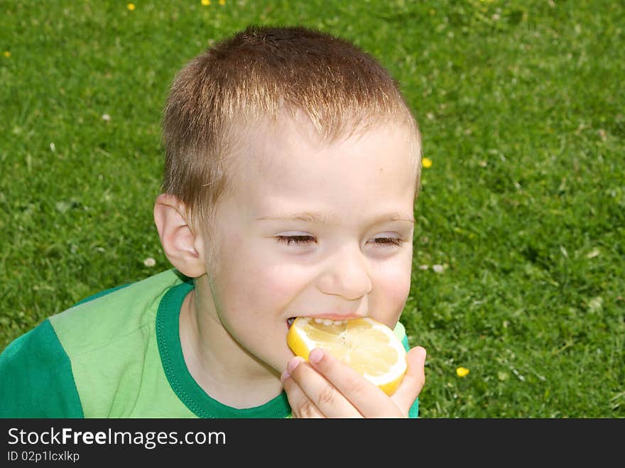 A child with pleasure eating lemon grass background. A child with pleasure eating lemon grass background