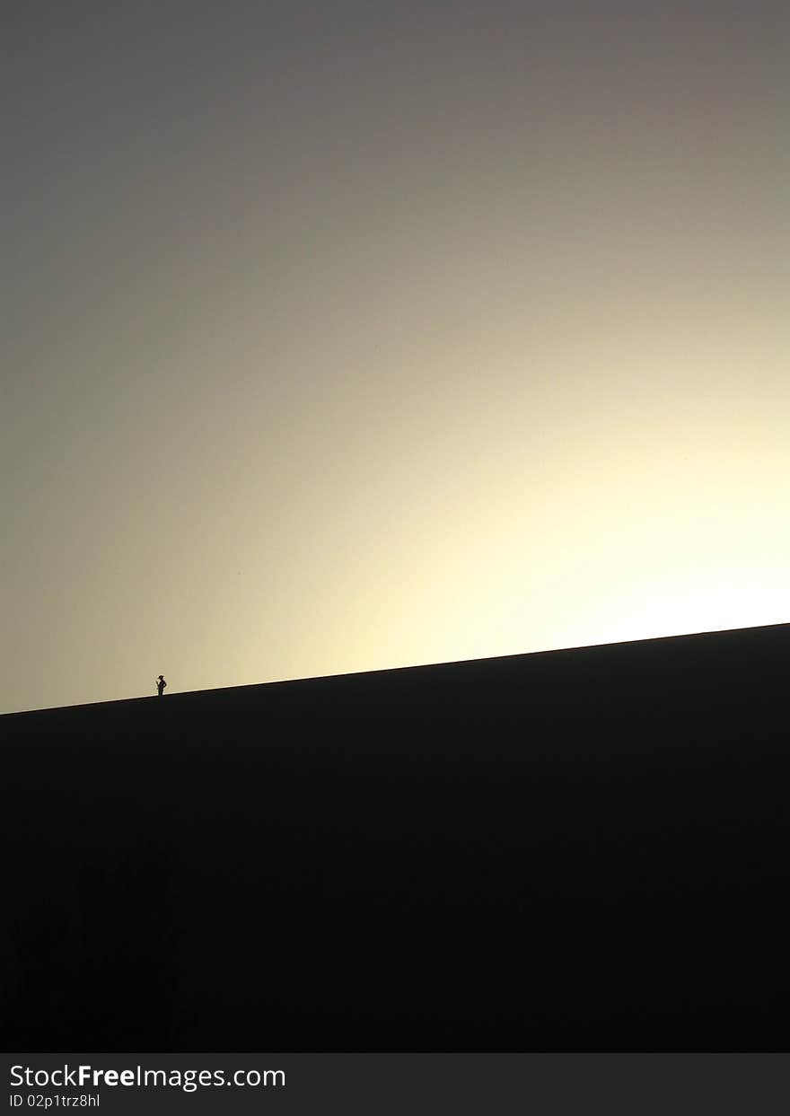 Peole on the dune under sunset