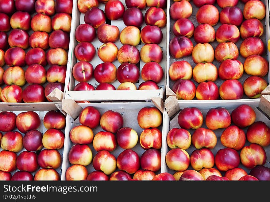 Juicy peaches in boxes in the sun