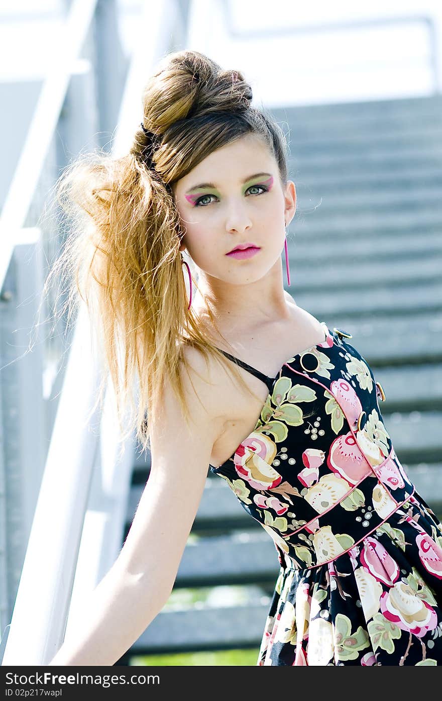 Teenager girl model presenting clothes in the park near the water and a bridge