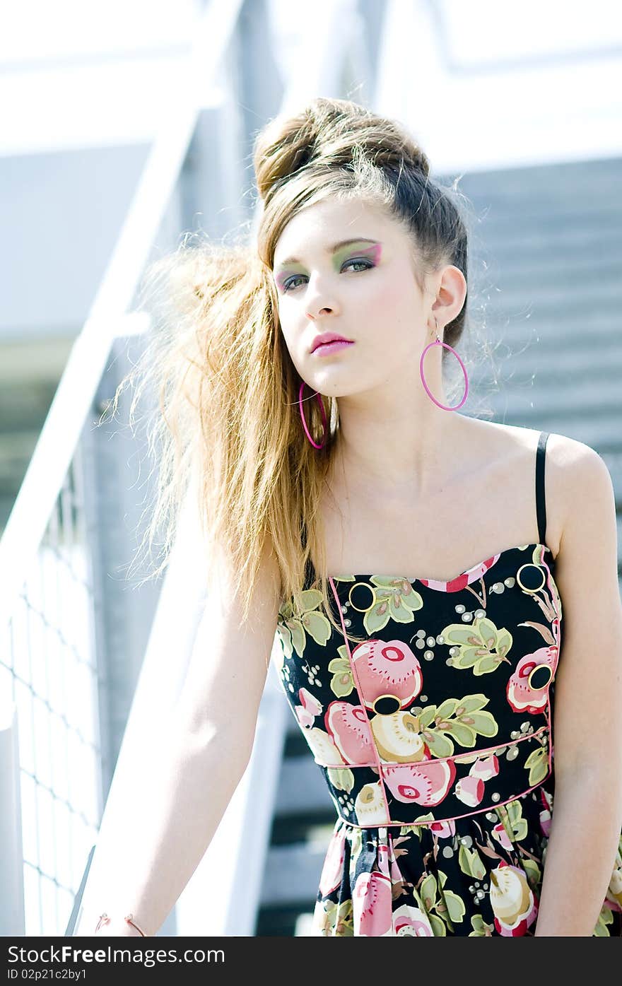 Teenager girl model presenting clothes in the park near the water and a bridge