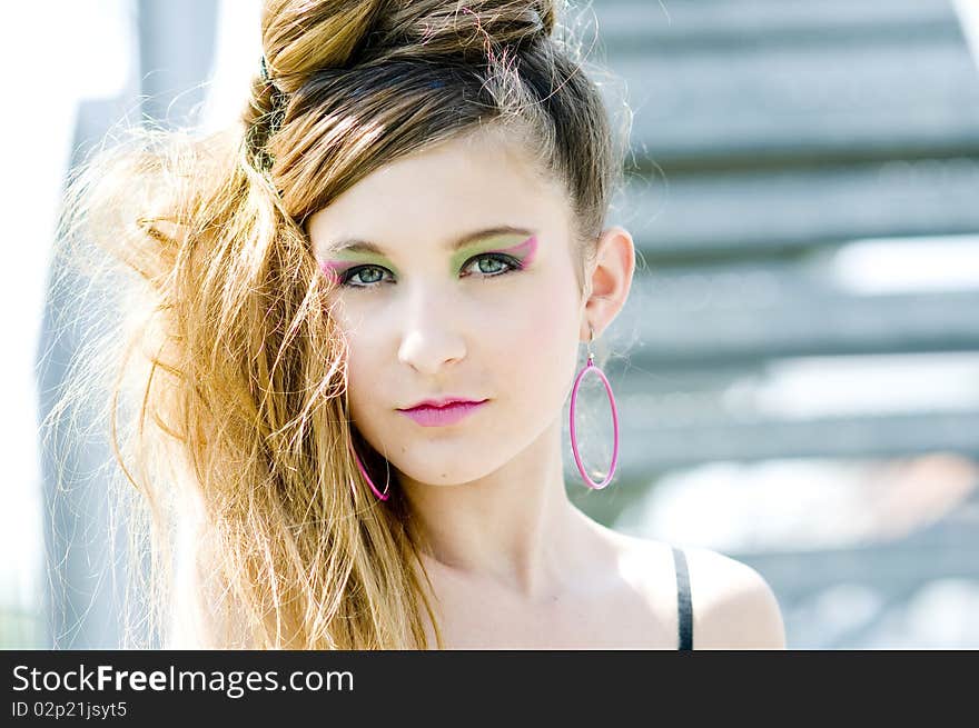 Closeup teenage girl model presenting clothes in the park near the water and a bridge. Closeup teenage girl model presenting clothes in the park near the water and a bridge