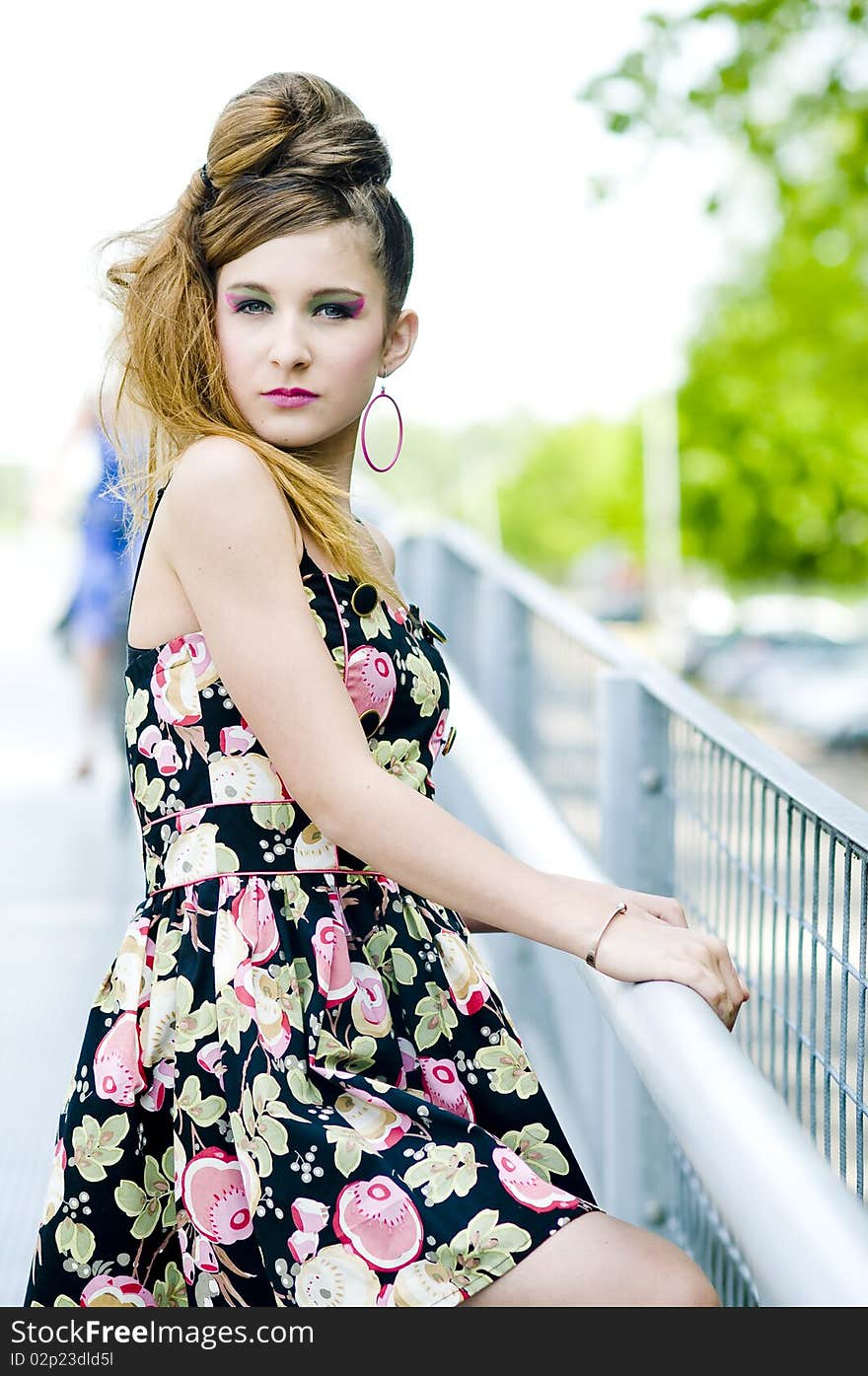 Teenager girl model presenting clothes on a bridge in the parc, light natural background. Teenager girl model presenting clothes on a bridge in the parc, light natural background