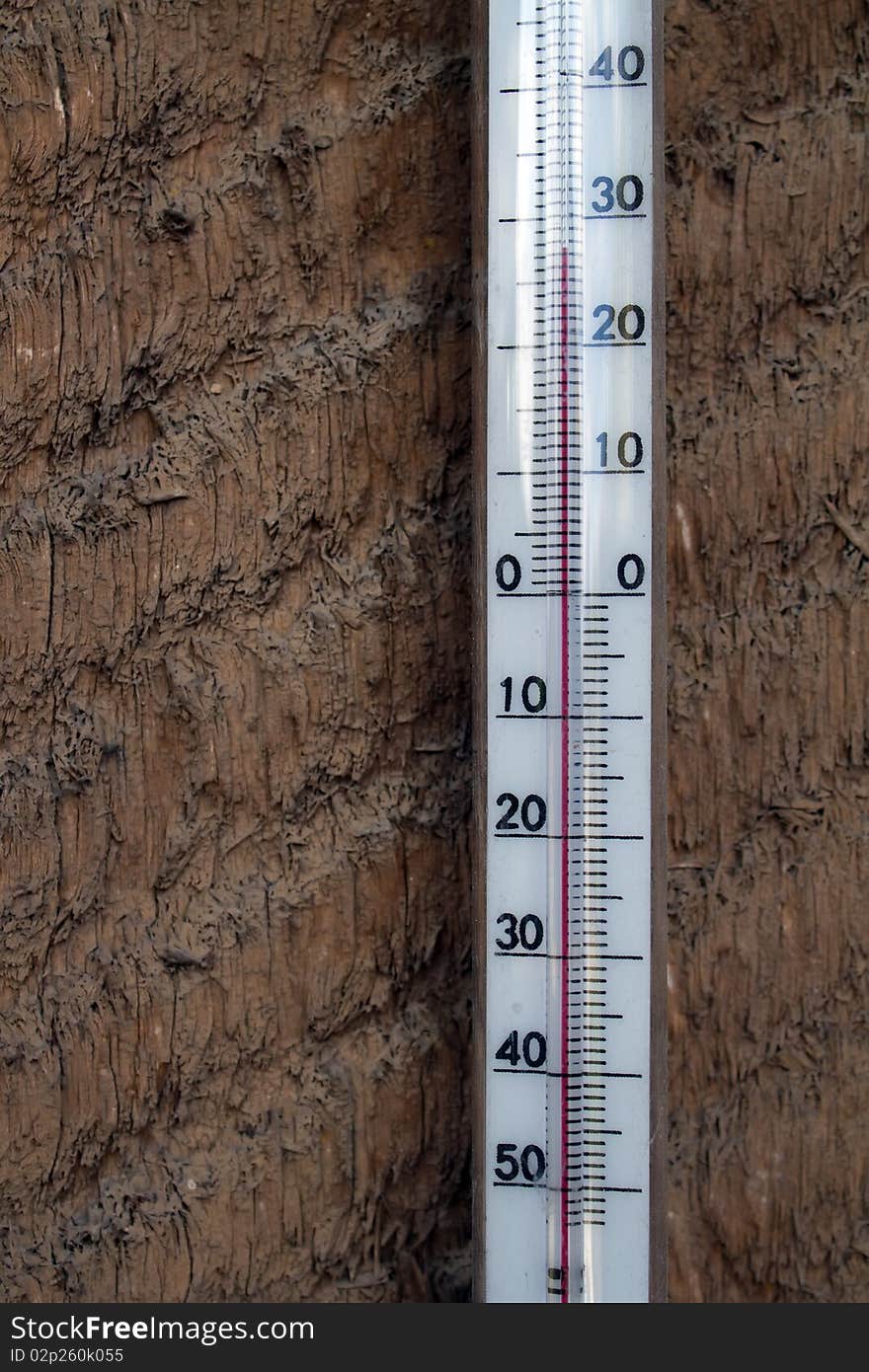 Tool   thermometer on a wooden wall from a board