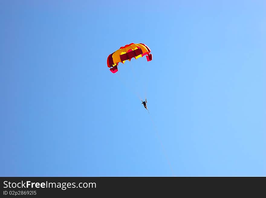 Man with a parachute in the blue sky