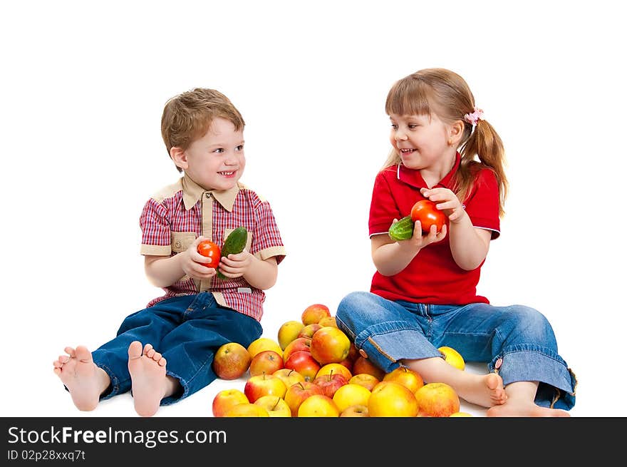 The girl and the boy with fruit and vegetables on white