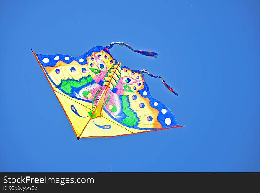 Colorful kite soaring in a blue sky. Colorful kite soaring in a blue sky