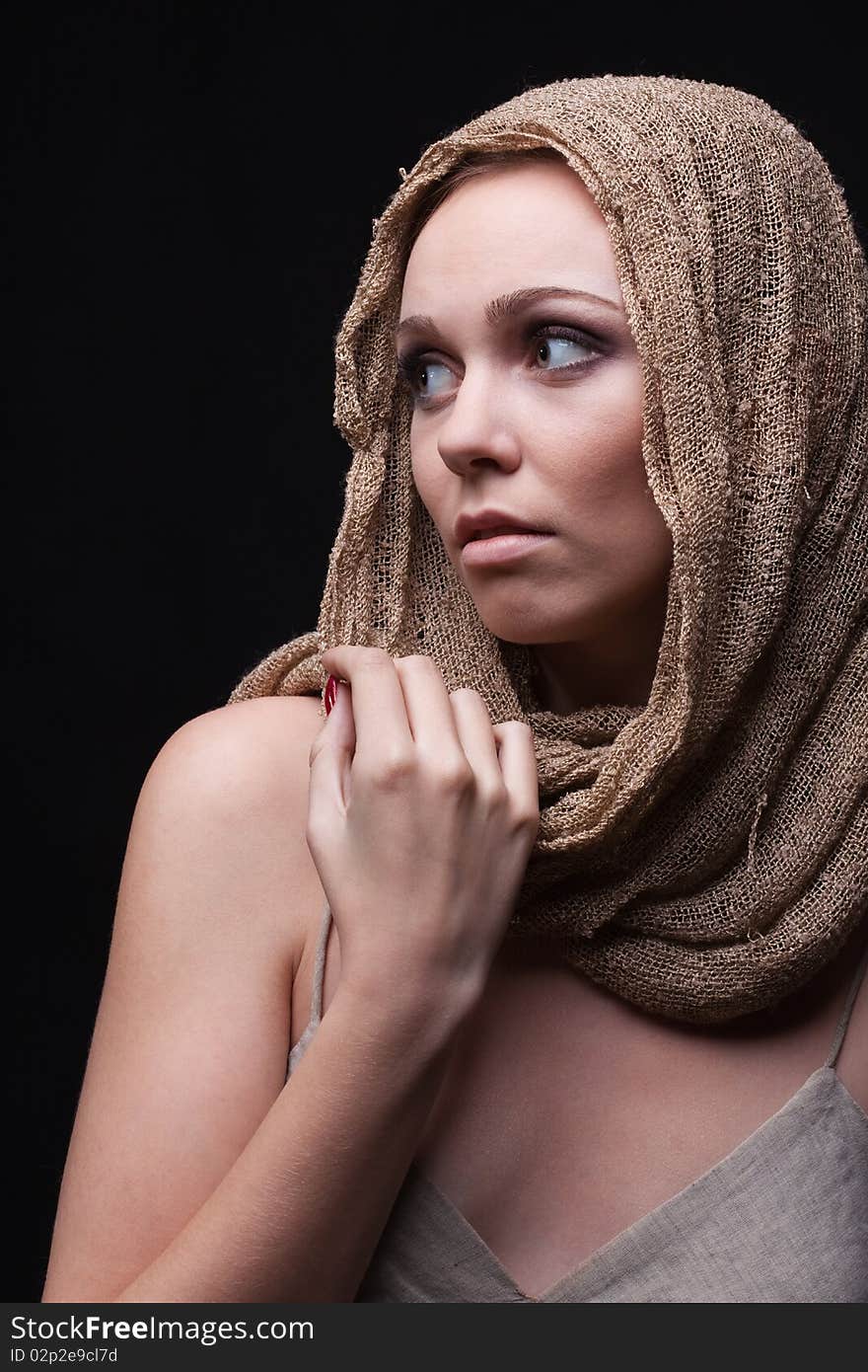 Studio closeup portrait of a beautiful woman with safari skarf on head holding hand on ahoulder. Studio closeup portrait of a beautiful woman with safari skarf on head holding hand on ahoulder