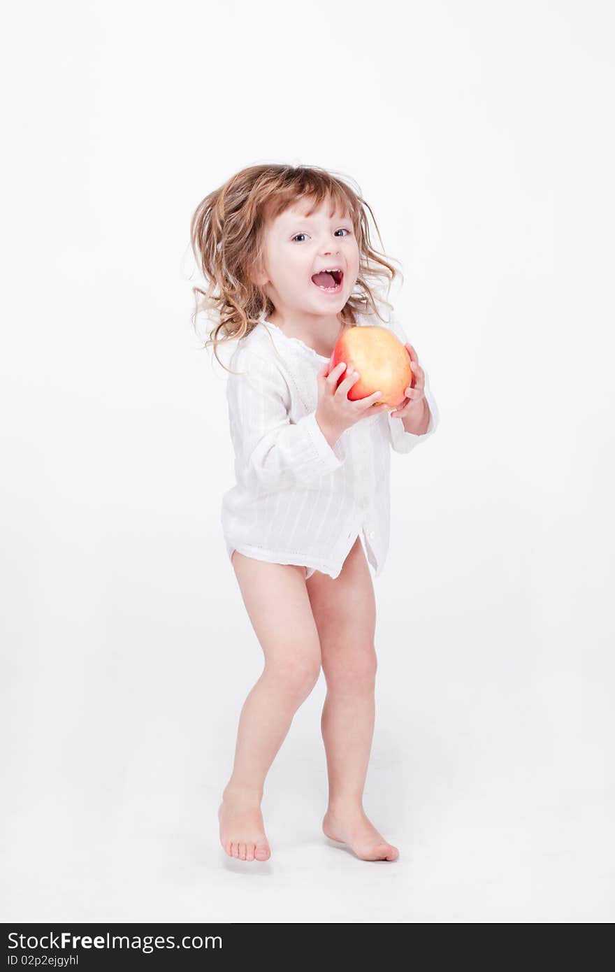 Studio porrait of cute child jumping with apple at hands