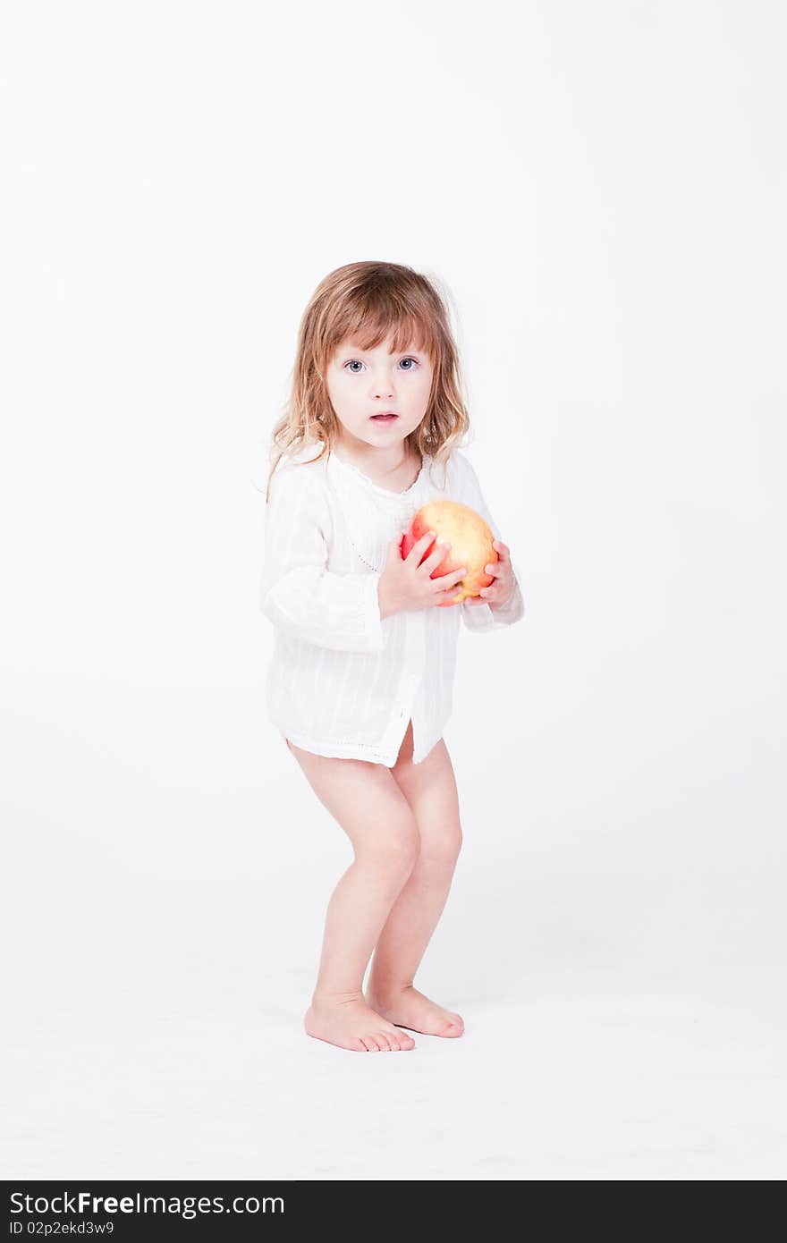 Studio porrait of cute child standing with apple at hands