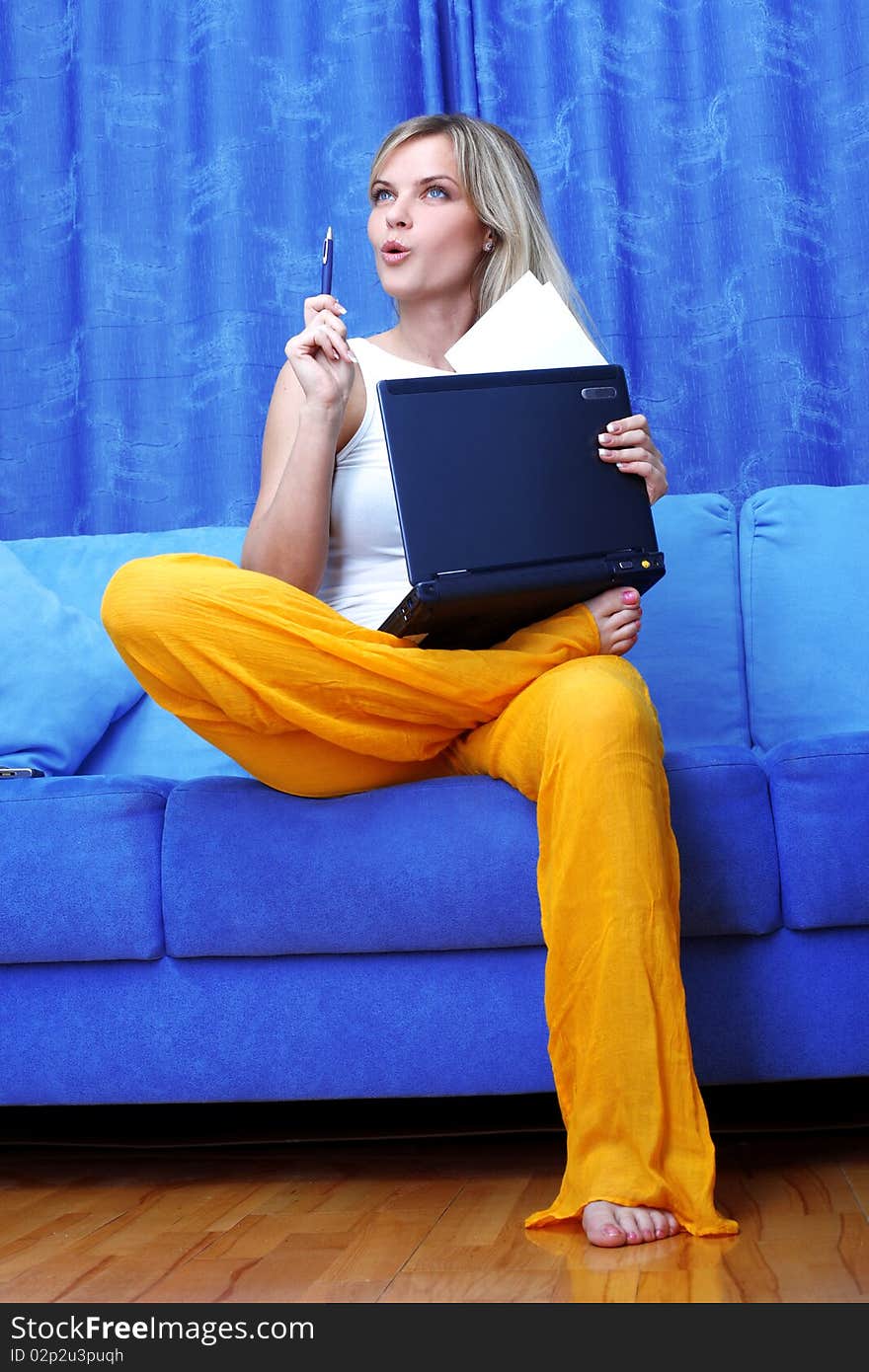 Thinking woman working with PC at home in sofa