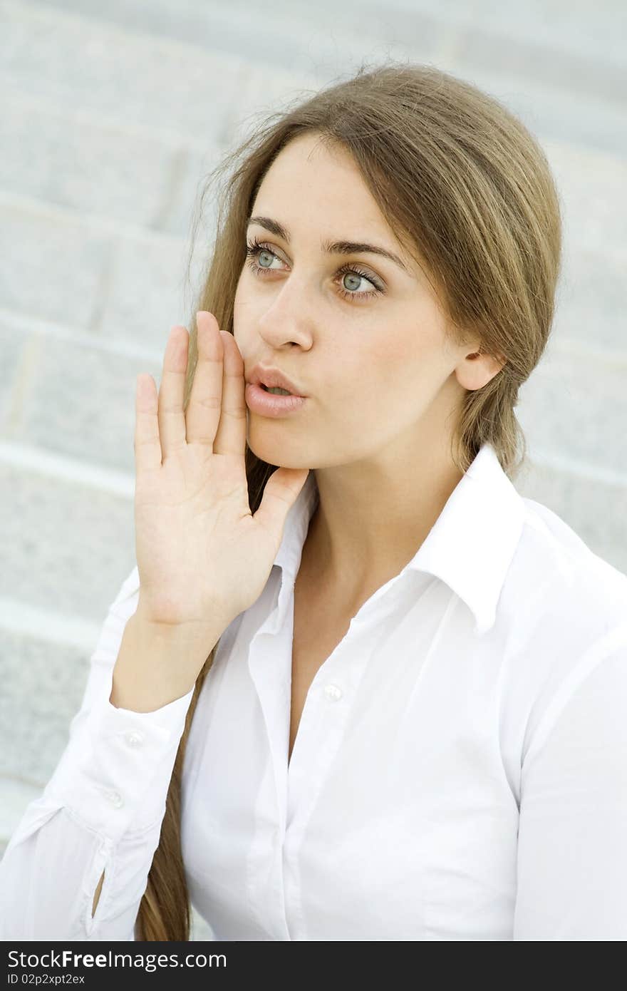 Young business woman on the background of stairs office building whispers trade secrets. Young business woman on the background of stairs office building whispers trade secrets