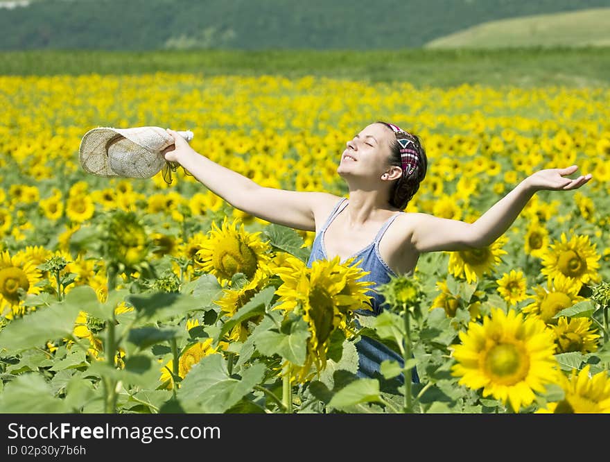 Young beautiful woman in a sunflower field. Young beautiful woman in a sunflower field