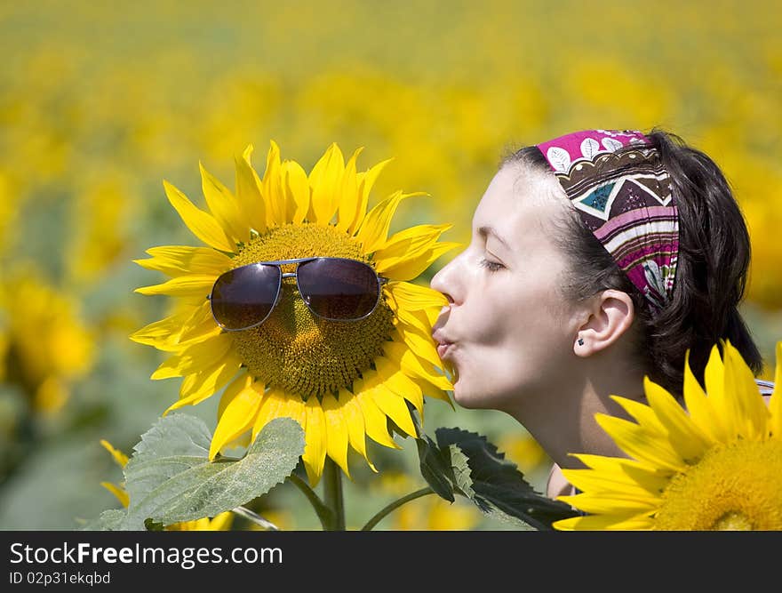 Young beautiful woman in a sunflower field. Young beautiful woman in a sunflower field