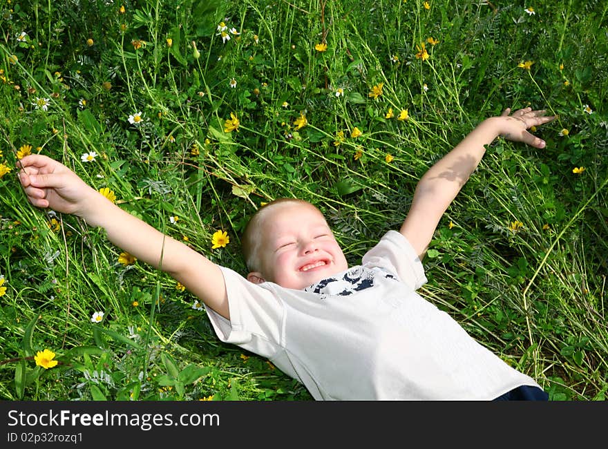 Child is lying on the grass and enjoying nature. Child is lying on the grass and enjoying nature