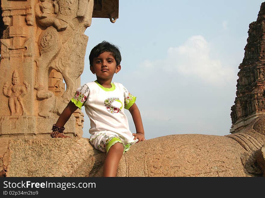 Girl sitting attentively on a stone platform. Girl sitting attentively on a stone platform