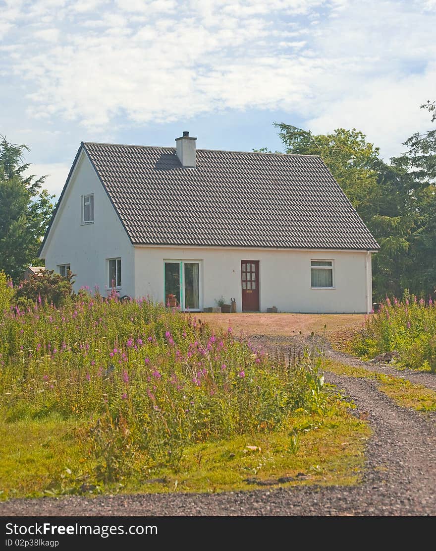 An image of a newly built  house with french doors at the front and with a chimney. An image of a newly built  house with french doors at the front and with a chimney.