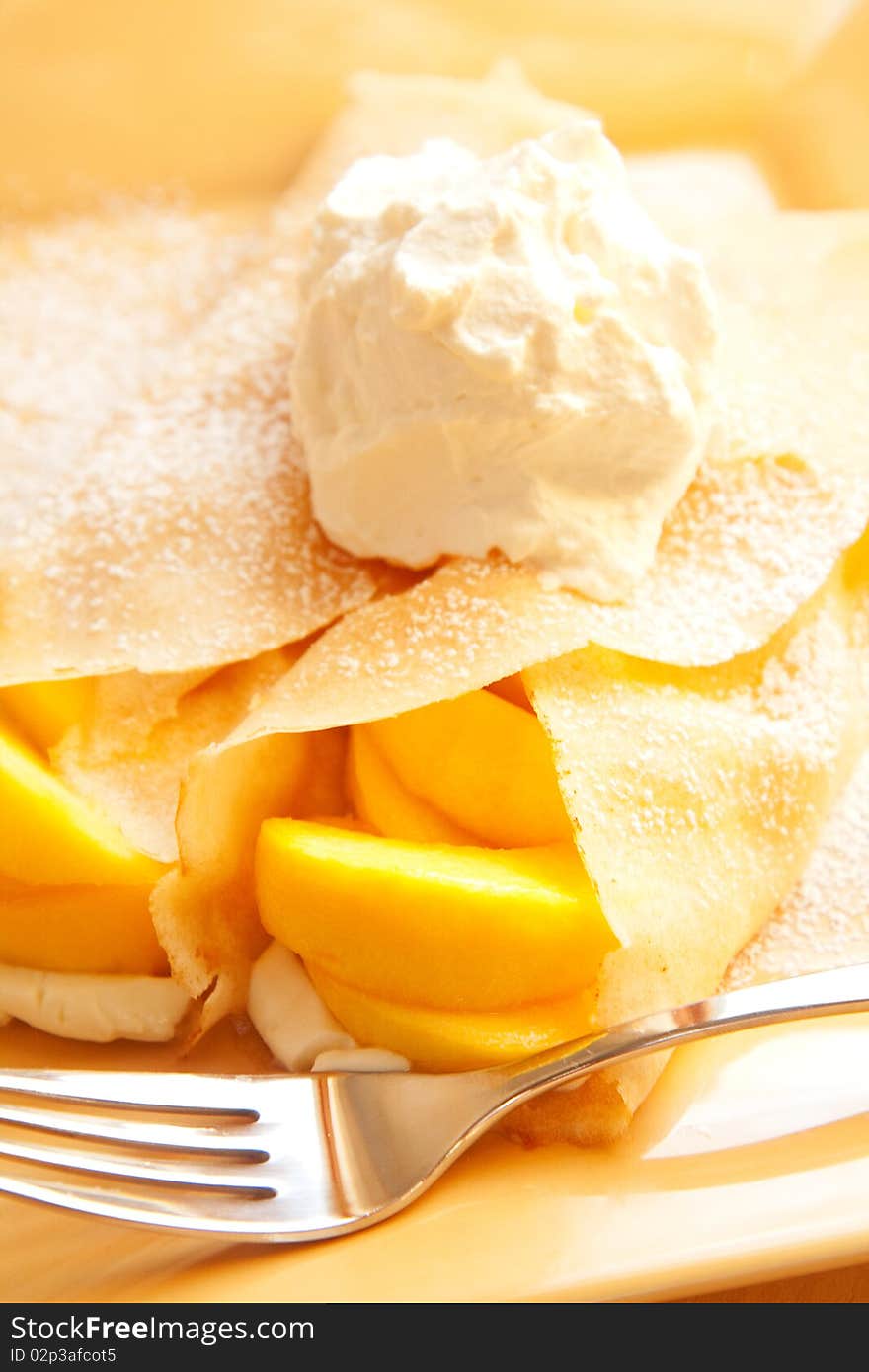 Peach crepes with a large dollop of whipped cream