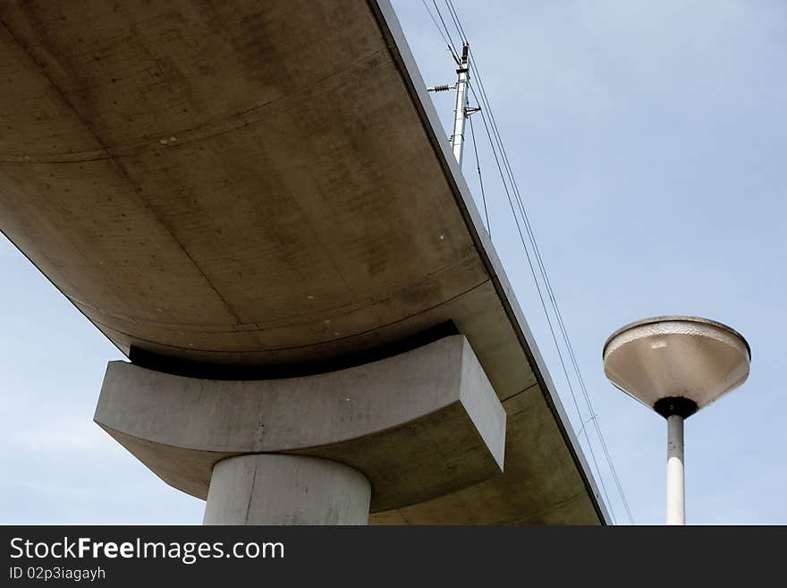 A lamp looks up at where the metro comes by. Both are powered by electricity. A lamp looks up at where the metro comes by. Both are powered by electricity.