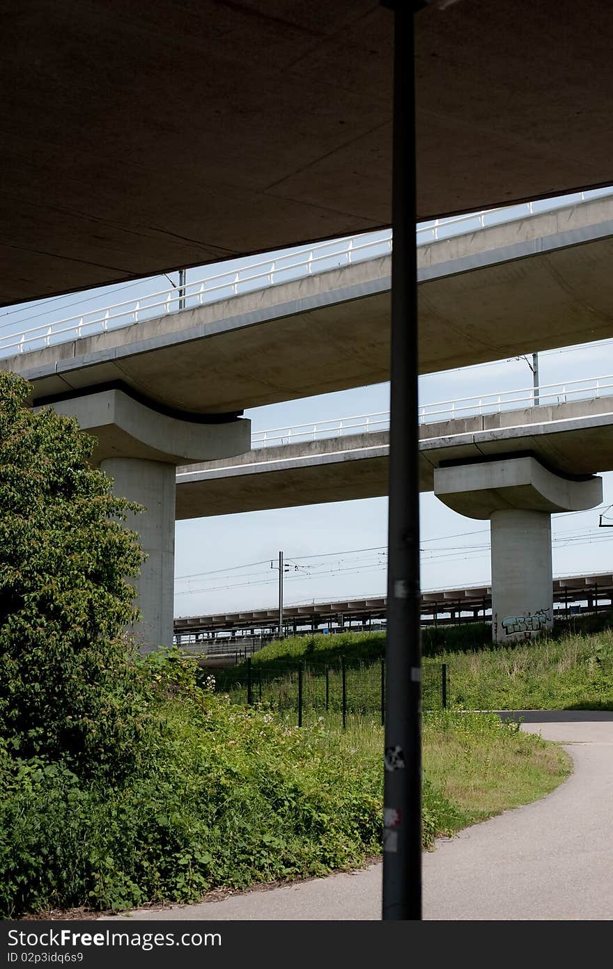 Concrete pillars standing somewhere in no-mans land, support the rails over which the metro travels.