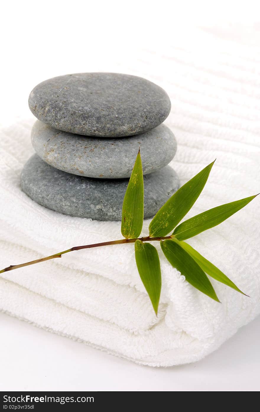 Zen stones with bamboo leaf on towel. Zen stones with bamboo leaf on towel