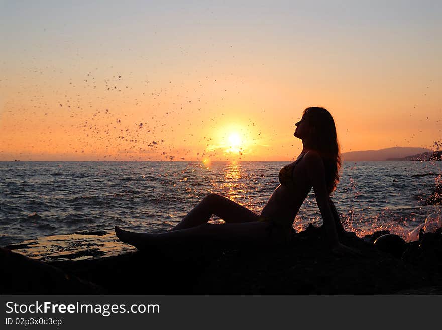 The girl sits on stones. Enjoys a decline. The girl sits on stones. Enjoys a decline