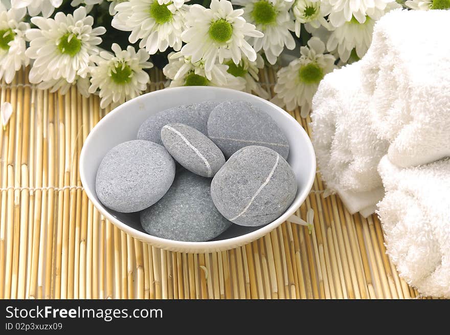 Bowl of stones with daisy and towel. Bowl of stones with daisy and towel