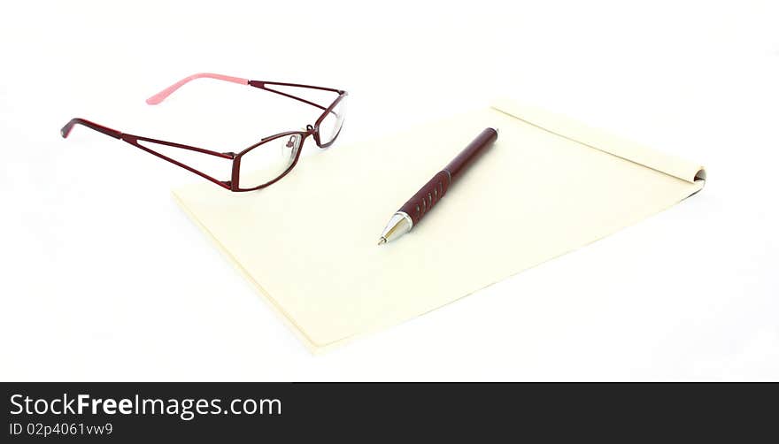 A pen a note and an eyeglasses isolated on a white background. A pen a note and an eyeglasses isolated on a white background