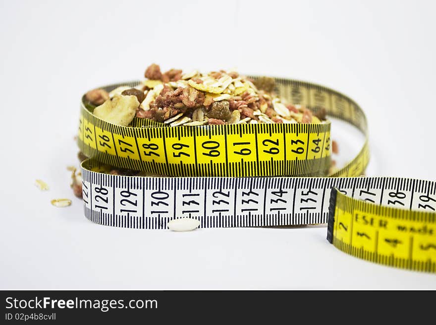 It is a small amount of cereals and a tape measure. It is a small amount of cereals and a tape measure