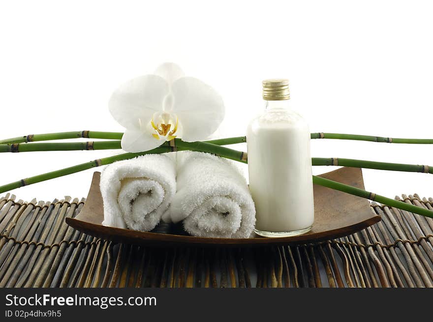 Wooden bowl of towel and orchid on mat. Wooden bowl of towel and orchid on mat